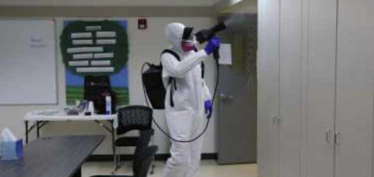 Person in hazmat suit cleaning